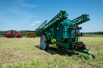 blue tractor in the field is preparing for chemical treatment of plants