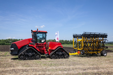 Obraz premium ciężki czerwony traktor na wystawie rolniczej w ruchu