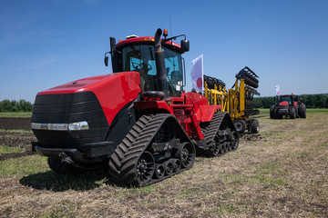heavy red tractor at agricultural exhibition in motion