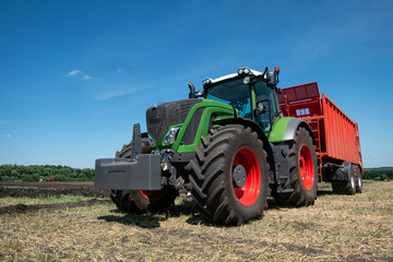 heavy green tractor for plowing the ground in the field