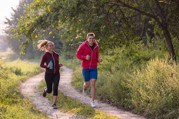 Fototapeta premium young couple jogging along a country road
