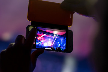 the person registers the night life by creating a movie using the camera built into the smartphone