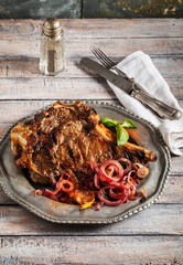 Beef steak with roasted onion on vintage metal plate