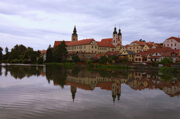 Obraz premium Scenic morning view of medieval Telc at sunrise. Buildings are reflected in the water. Famous touristic place and travel destination in Europe. A UNESCO World Heritage Site. Telc, Czech Republic