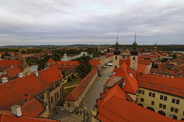 Fototapeta premium Red tile roofs in medieval city. Aerial view of Telc with main square and towers of the Church of the Holy Name of Jesus. A UNESCO World Heritage Site. Telc, Czech Republic
