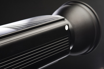 Close-up - a beautiful ceiling and body of a professional black studio illuminator. Studio equipment concept