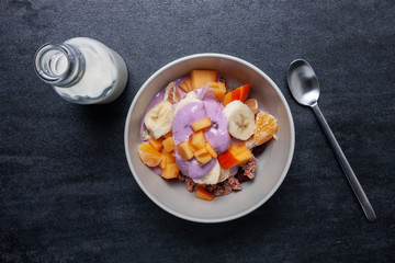 Müsli mit Früchten, Milch und Joghurt zum Frühstück