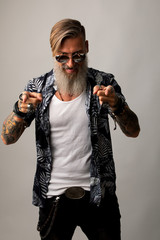 Porträt eines attraktiven netten Mannes mit Bart und Sonnenbrille, der mit dem Finger auf Sie zeigt