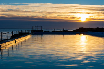 Fototapeta na wymiar Sunrise at Whale Beach, Sydney, Australia. Morning reflections at the ocean pool.