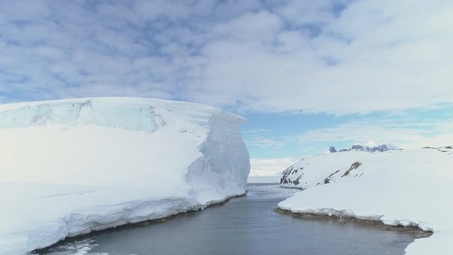 Ocean Pass Through Iceberg And Snow Antarctica Land. Aerial Drone Flight Overview. Ice And Snow Covered Glaciers Of Antarctic Continent. Winter Polar Landscape. Wilderness. 4k Footage.