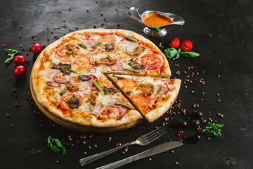 Tasty meat pizza with various ingredients on black background