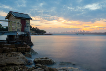 Sunset over Sydney Harbour at Camp Cove. Sydney skyline in the background