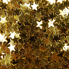 Golden decorate star shaped confetti. Christmas maclground. 