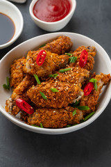 Chicken nuggets with sauce and pepper on a dark background. Copy space.