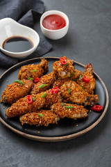 Chicken nuggets with sauce and pepper on a dark background. Copy space.