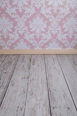 Pink damask wallpaper and white wooden floor