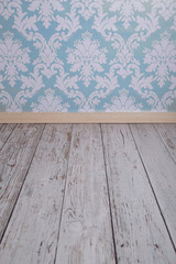 Blue damask wallpaper and white wooden floor