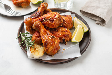 Chicken legs with sauce, rosemary and lime on a white background. Copy space.