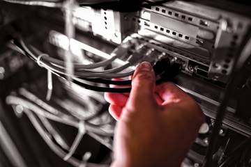 Close-Up of technician plugging patch cable in a rack mounted