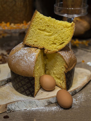 Slice of Cake on Top of a Panettone with Two Raw Eggs - Typical Italian Christmas Cake