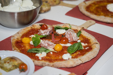 Pizza Maker who Prepares a Delicious Pizza with Bacon and Cherry Tomatoes
