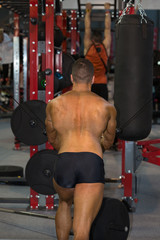 Young Man Exercising with Fitness Machine at Gym: Back view © GioRez
