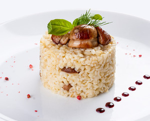 Rice with porcini mushrooms. On a white plate