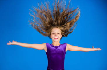 Obraz na płótnie Canvas Ballroom latin dance hairstyles. Kid girl with long hair wear dress on blue background. Hairstyle for dancer. How to make tidy hairstyle for kid. Things you need know about ballroom dance hairstyle