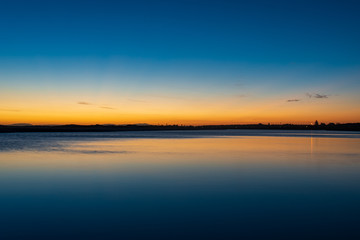 Fototapeta na wymiar Sunset and reflection over still water at Harrington, Australia