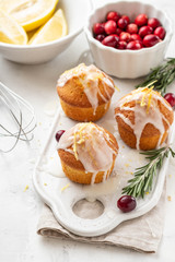 Muffins, cakes with cranberry and lemon on a white board.
