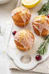 Muffins, cakes with cranberry and lemon on a white board.