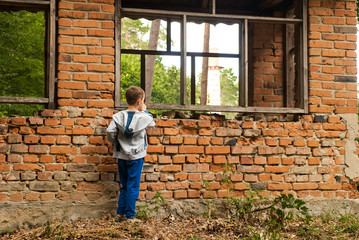 Fototapeta na wymiar Boy in an old abandoned house