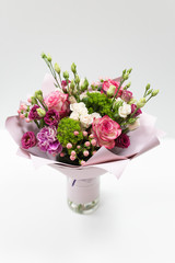 Beautiful bouquet in pink paper on a light background