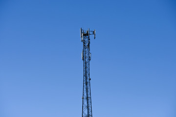Cellular radio tower antenna. Mobile GSM Base Station Tower with blue sky.