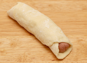 Cooking sausages in the dough in the kitchen