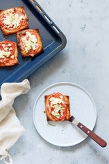 Ruddy toast with baked tomatoes, cheese and herbs. Morning breakfast. Crisp, Grilled, baked toast.