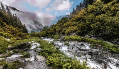 Wonderful landscape with mountain river and sky. Rocky waterfall in the mountains.Balea waterfall...