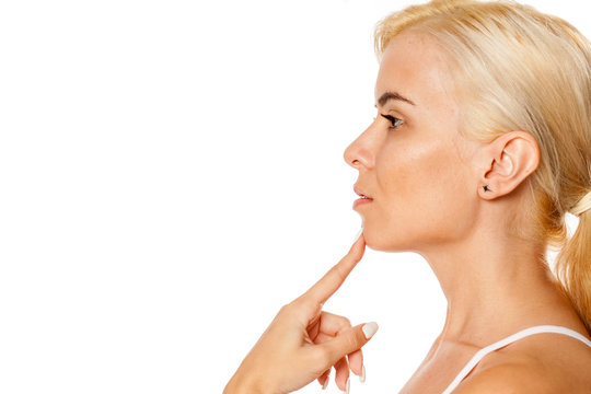 Portrait of beautiful blonde woman touching her chin on white background