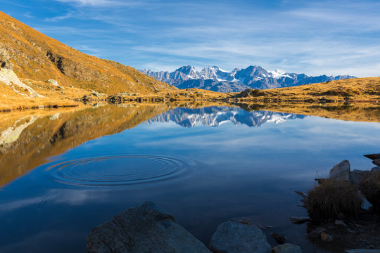 Peaks of Bernina Group reflected in the blue Lago Arcoglio during autumn, Valmalenco, Valtellina, Lombardy