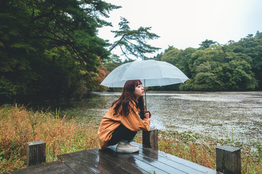 Portrait of woman crouching under umbrella