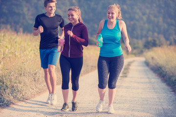 young people jogging on country road