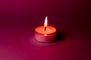 candle in the dark claret red purple background