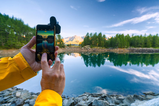 Hiker snaps photos with smartphone, Lago Azzurro, Spluga Valley, Sondrio province, Valtellina, Lombardy