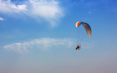Flying Paramotor against a Blue Sky