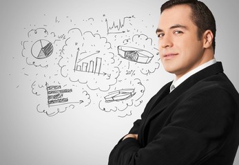 Young businessman thinking about charts and graphics