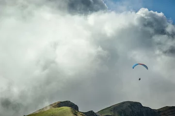 Deurstickers Luchtsport Paraglider vliegt over de bergen