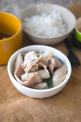 Suki in broth with pork on white bowl