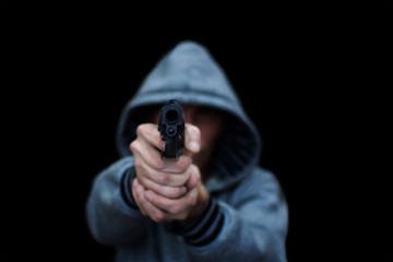 A man aims from a pistol. Isolated on a black background. The concept of threat, danger, defense