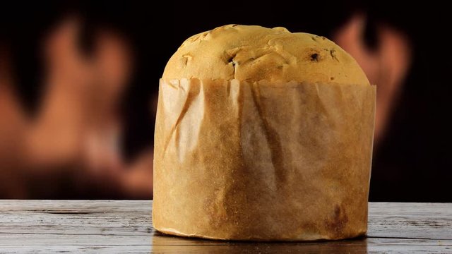 panettone on wooden table, christmas decoration, fire in the background