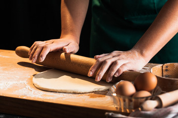 Hands of a chef baker woman kneading dough